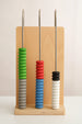 Colorful abacus-like tool with wooden base on a plain background